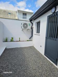 a white house with a black garage door at La KAZ SAMANY in Sainte-Suzanne