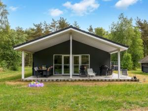 a black house with a white roof at Holiday Home Bæver - 1km from the sea by Interhome in Læsø