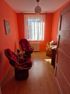 an orange room with two chairs and a table at Apartment in Kietrz