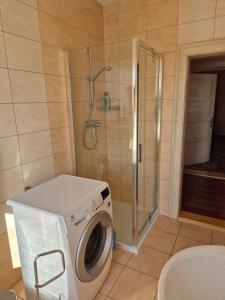 a washing machine in a bathroom with a shower at Apartment in Kietrz