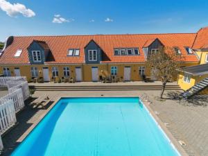 an empty swimming pool in front of a house at Holiday Home Elemine - 500m from the sea by Interhome in Gudhjem