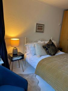 a bedroom with a bed and a table with a lamp at Number 78 Guest house M56 junction 12 located 5 minutes drive from Frodsham Continental breakfast Included in Frodsham +9 photos