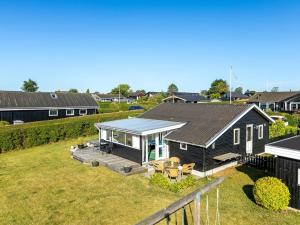 a small house with a porch and a deck at Holiday Home Raymond - 175m from the sea by Interhome in Hejls