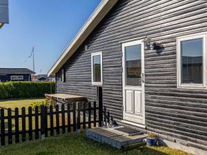 a house with a white door and a wooden fence at Holiday Home Raymond - 175m from the sea by Interhome in Hejls