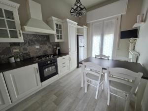 a kitchen with white cabinets and a table and chairs at Casa Dream - Milan in Cesano Boscone +2 photos