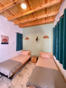 zwei Betten in einem Zimmer mit Holzdecken in der Unterkunft Nubian House Dahab - البيت النوبي دهب in Dahab + 58 Fotos