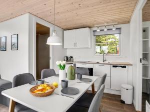 a kitchen and dining room with a white table and chairs at Holiday Home Brun - 900m from the sea by Interhome in Marielyst