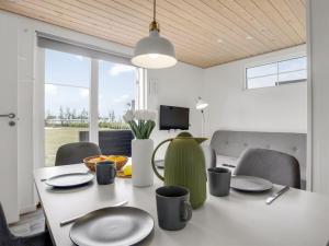 a dining room with a white table and chairs at Holiday Home Brun - 900m from the sea by Interhome in Marielyst