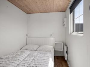 a white bedroom with a bed and a window at Holiday Home Brun - 900m from the sea by Interhome in Marielyst