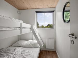 a bedroom with two bunk beds and a window at Holiday Home Brun - 900m from the sea by Interhome in Marielyst +7 photos