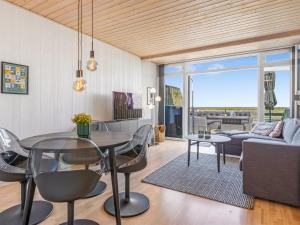 Una sala de estar con una mesa y sillas y un sofá. en Apartment Kjera - 2-4km from the sea by Interhome, en Rømø Kirkeby