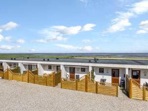 Un edificio blanco con una valla delante. en Apartment Kjera - 2-4km from the sea by Interhome, en Rømø Kirkeby
