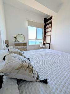 El PuertitoCHC-Balcon de Bajamar的卧室配有带枕头的大床和窗户。