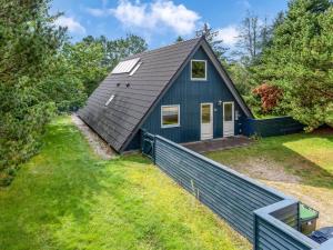 a blue house with a fence in front of it at Holiday Home Hannele - 10km from the sea by Interhome in Oksbøl