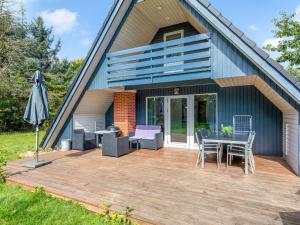 a deck with a table and chairs and a house at Holiday Home Hannele - 10km from the sea by Interhome in Oksbøl