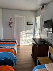 a room with two beds and a tv and a door at La Martinna 3 in Trinidad