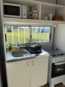 a small kitchen with a sink and a microwave at La Martinna 3 in Trinidad +9 photos
