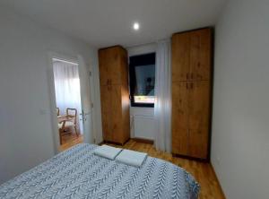 a bedroom with a large bed and a window at Apartmani Katnic in Jagodina