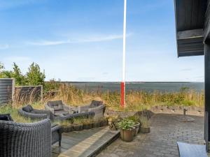 a patio with furniture and a view of the ocean at Holiday Home Diderik - 20m to the inlet by Interhome in Roslev