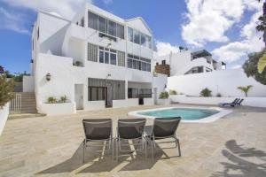 una casa bianca con piscina e sedie di Casa Queen Vetusta a Argana
