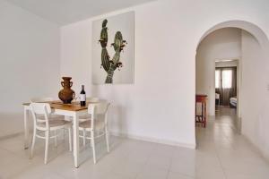 una sala da pranzo bianca con tavolo e sedie di Casa Queen Vetusta a Argana