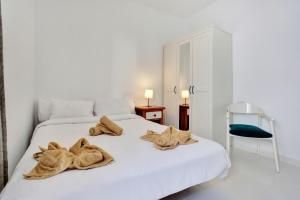 una camera da letto con un letto bianco con asciugamani sopra di Casa Queen Vetusta a Argana Altre 39 foto