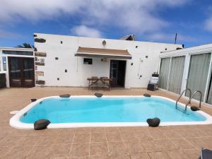 una gran piscina frente a una casa en Casa Las Palmeritas, en Tinajo