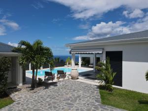 a villa with a swimming pool and a house at Villa Blanca in Case-Pilote
