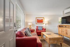 a living room with a red couch and a table at Downtown Cozy Home Base - Purple Sage 1 in Moab