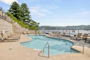 a swimming pool with chairs and tables and aretched at Luxury Lakefront Condo in Wisconsin Dells in Lake Delton