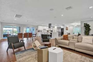 a living room with a couch and chairs and a kitchen at Luxe 4BR Waterfront w Htd Pool 5min to beach in Fort Lauderdale +56 photos