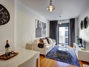 uma sala de estar com um sofá branco e uma mesa em Sonel Investe Martim Moniz Apartment by Get Your Stay em Lisboa