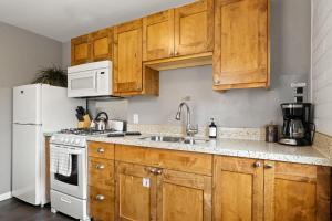 eine Küche mit Holzschränken und einem weißen Kühlschrank in der Unterkunft Downtown Cozy Home Base - Purple Sage 4 in Moab + 16 Fotos