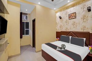 a hotel room with a bed and a television at Hotel O Moon Hotel in Ghaziabad