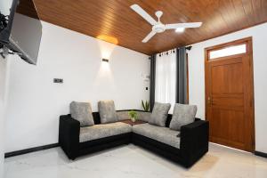 a living room with a couch and a ceiling fan at Velora Ridge in Kundasale