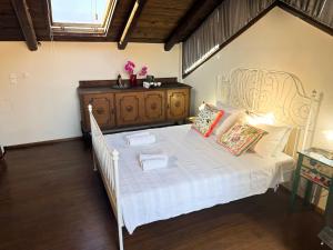 a bedroom with a white bed and a dresser at Happy Place in Rethymno Town +16 photos