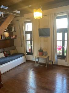 a living room with a couch and two windows at Happy Place in Rethymno +16 photos