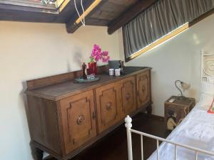 a bedroom with a wooden dresser with flowers on it at Happy Place in Rethymno