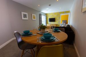 ein Wohnzimmer mit einem Holztisch und Stühlen in der Unterkunft Cosy Dragons, Sherlock Holmes in Abergavenny