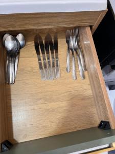a wooden drawer with utensils in a drawerlictsangering at Ap em ótima localização in Cuiabá +11 photos