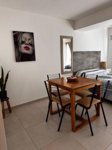 a dining room with a table and chairs and a bed at Monoambiente a estrenar ubicado en el centro de la Falda in La Falda