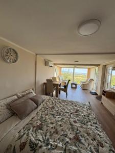 a bedroom with a large bed with a table and chairs at Vila POGLED in Arandelovac