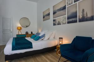 波利尼Clos Grimont的一间卧室，有一张床和一把蓝色椅子