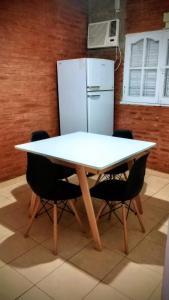 a white table with chairs and a refrigerator at Casa Finca in Santiago del Estero