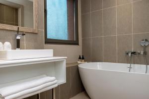 a bathroom with a white tub and a sink at Azalaï Hôtel Ouagadougou in Ouagadougou