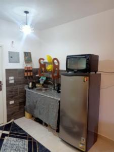 a kitchen with a tv on top of a refrigerator at شاليه بالساحل الشمالى قرية نيو كوست الكيلو 77 قبلى الطريق بشاطىء خاص in El Alamein