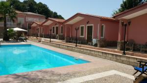 a swimming pool in front of a house at Hotel La Pineta in Spilinga