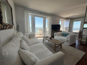 Una sala de estar con muebles blancos y grandes ventanales. en Le Balcon de Tresmeur, en Bonne Nouvelle 17 fotos más