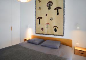 ein Schlafzimmer mit einem Bett und einem Gemälde an der Wand in der Unterkunft N i d e l ê in Nida