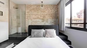 Un dormitorio con una cama y una pared de ladrillo. en Luxury 3 Bedrooms Apt near Hilton hotel, en Tel Aviv